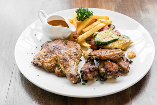grilled chicken peri peri, BBQ Portuguese groumet griled cuisine, with fries and grilled vegetable.