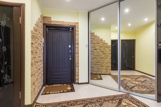 Spacious entrance hall in the apartment with built-in wardrobe and huge mirrors