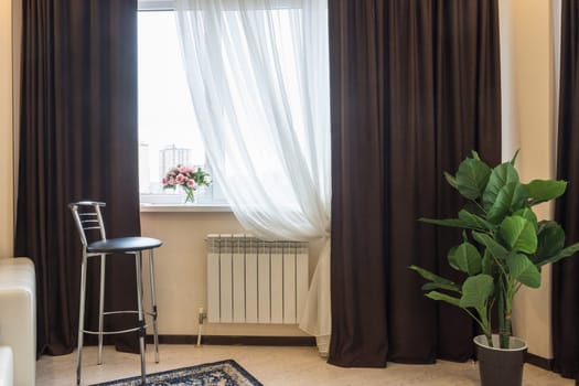 Interior element, bar stool, curtain windows, vase with flowers on the window