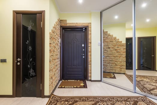 Spacious entrance hall in the apartment with built-in wardrobe and mirrors