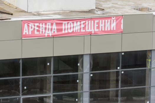 Shabby sign "rental of premises"" on the facade of the new shopping center"