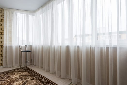 Curtained glazed spacious balcony in the apartment