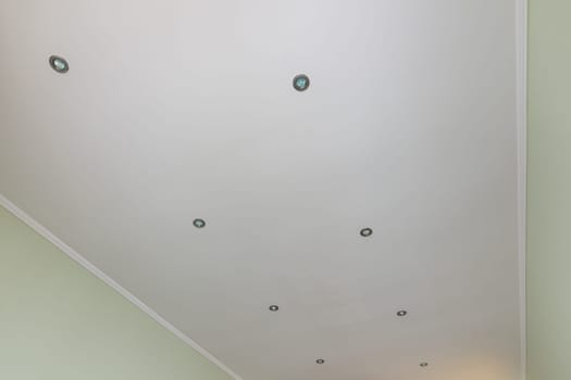 Plastered and painted ceiling in the room, with spotlights installed