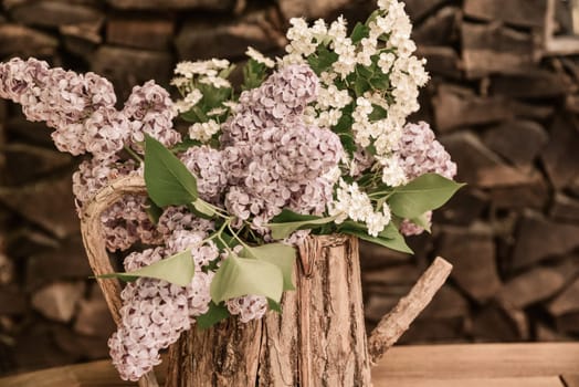 lila Flieder in einer Holzkanne Blumenstrauß