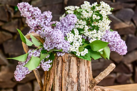 lila Flieder in einer Holzkanne Blumenstrauß
