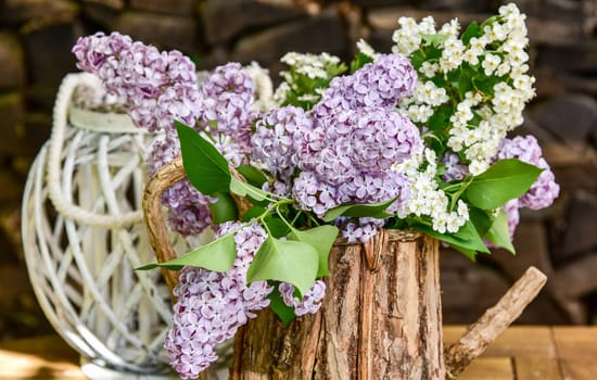 lila Flieder in einer Holzkanne Blumenstrauß
