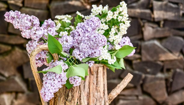 lila Flieder in einer Holzkanne Blumenstrauß