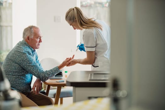 Senior diabetic man is having a check up at home from a district nurse. She is checking his blood glucose levels.
