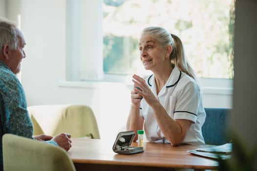 Nurse is giving a home visit to a senior diabetic man. They are discussing treatment and he has given her a urine sample.