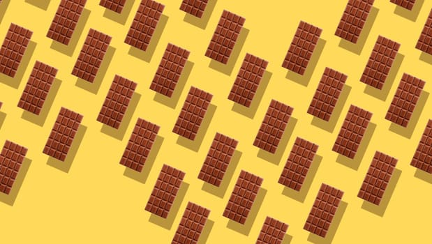 Pattern of small duplicating milk chocolate tablets on yellow background with shadows, viewed from above in full frame