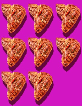 Eight grilled marinated T-bone steaks with hot red chili pepper garnish on bright magenta background with copy space and drop shadows
