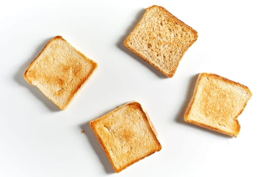 Set of four fried toast bread slices isolated on white background with shadow, viewed from above