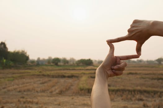 Hands making frame with sunset. Close up of woman hands making frame gesture.
