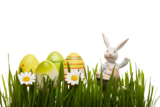 Colored easter eggs, easter rabbit and spring green grass on a white background. Greeting card.