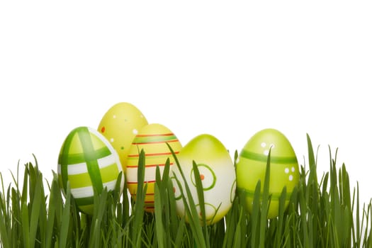 Colored easter eggs and spring green grass on a white background. Greeting card.