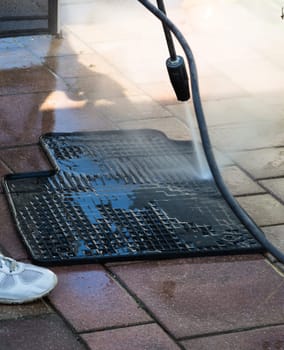 Details of car cleaning - cleaning woman in the professional cleaning of car mat