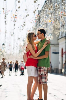 girl and guy on the background of the alley of garlands.