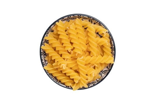 Vegetable food. A bowl of uncooked raw spirelli or noodles isolated on a white background. Healthy eating. Top view with space for product montage.