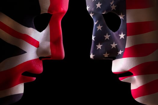 USA and GB face off head to head concept with human mask outlines covered in national flags symbols. Black background space for text