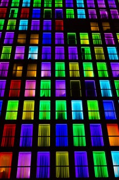 Colored windows texture.  Windows illuminated by neon lights background.