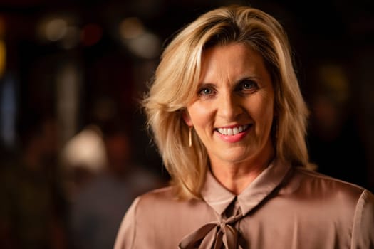 Headshot of a mature woman smiling and looking at the camera.