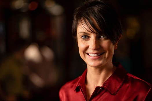 Headshot of a mature woman smiling and looking at the camera.