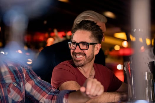 Mid adult male friends enjoying a beer together in a bar.