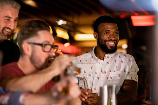 Three mid adult male friends enjoying a beer together in a bar.