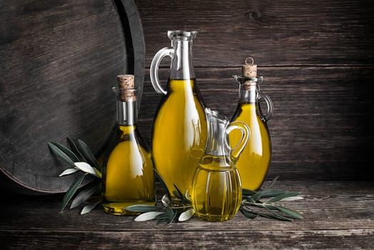 Bottles of Extra virgin healthy Olive oil with barrel background