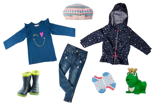 Collage set of little girl clothes isolated on a white background. The collection of a rain jacket, jeans , sweater, rubber boots, hood and socks. Childrens spring and autumn fashion.