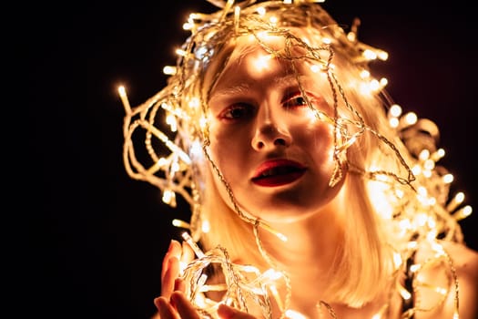 portrait of a girl with a garland on black background.