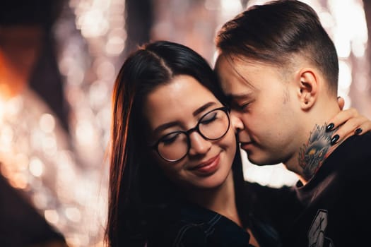 Couple in fashionable clothes on a shiny background.