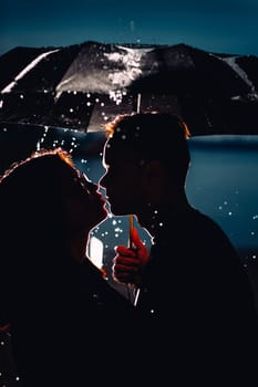 young man and woman under an umbrella and rain.