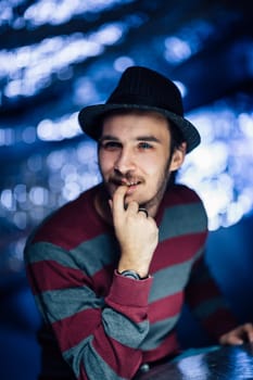 portrait of a guy in a hat on a blurred background.