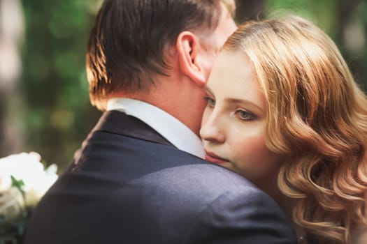 bride and groom on the background of trees and forest sun.