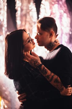 Couple in fashionable clothes on a shiny background.