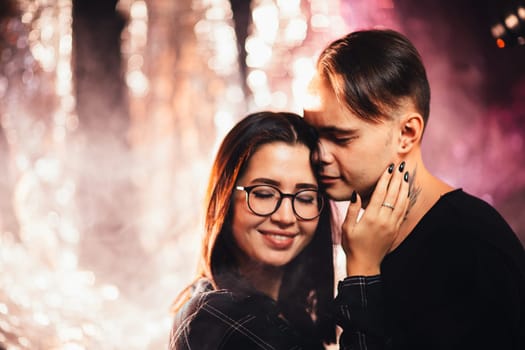 Couple in fashionable clothes on a shiny background.