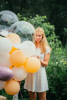 young girl with balloons on nature background.