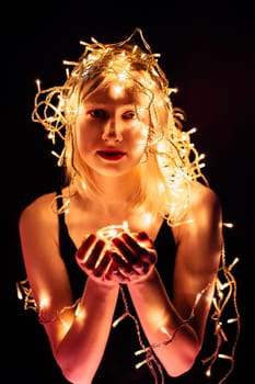 portrait of a girl with a garland on black background.