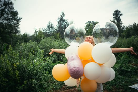 portrait of young girl with balloons on nature background.