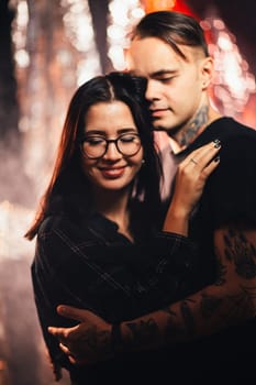 Couple in fashionable clothes on a shiny background.