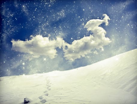 Winter landscape with snow covered hill and cloudy blue sky