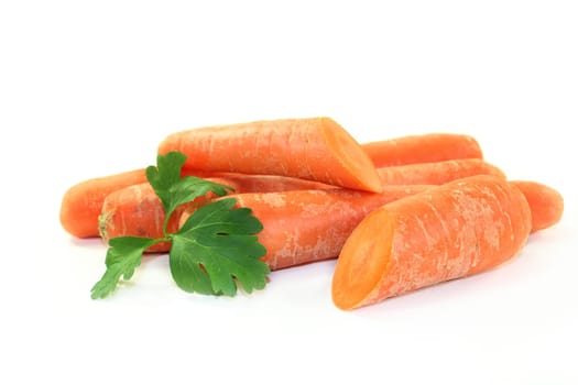 orange carrots with petersile against a white background