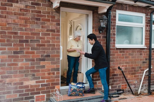 Teenage boy is delivering groceries to his grandmother.