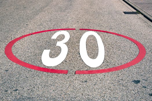 Detail from the Numbers thirty 30 Speed Limit painted on a Street