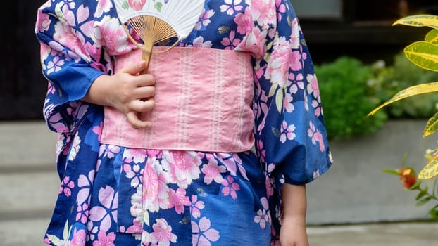 THe Young girl wearing Japanese kimono standing in the park
