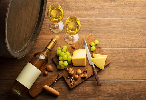 Bottle of white wine with snack food on old board and barrel. Wine bottle mockup.
