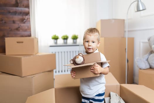 Cute toddler helping out packing boxes and moving