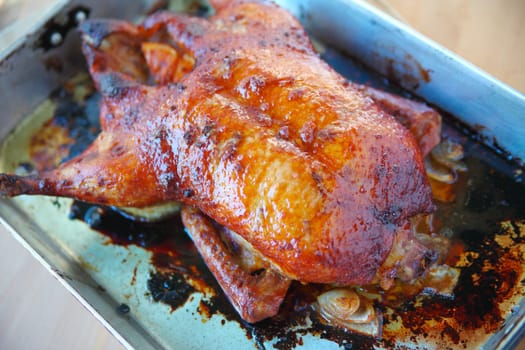 Overhead view of cooked duckling in roasting pan