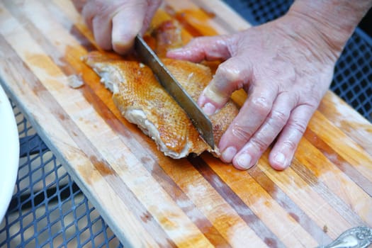 Preparing roast duck on a patio table